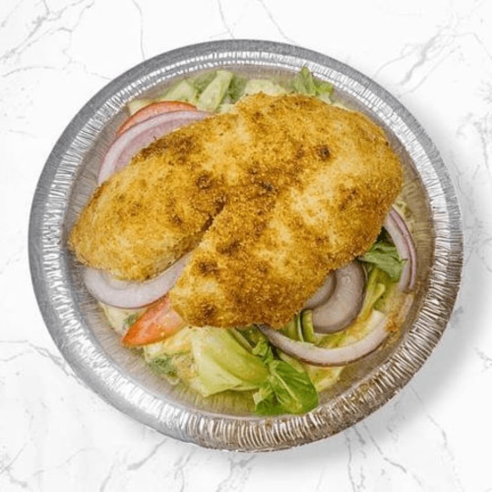 Halal fried chicken cutlet over a salad with lettuce, tomatoes, and red onions in a foil container.