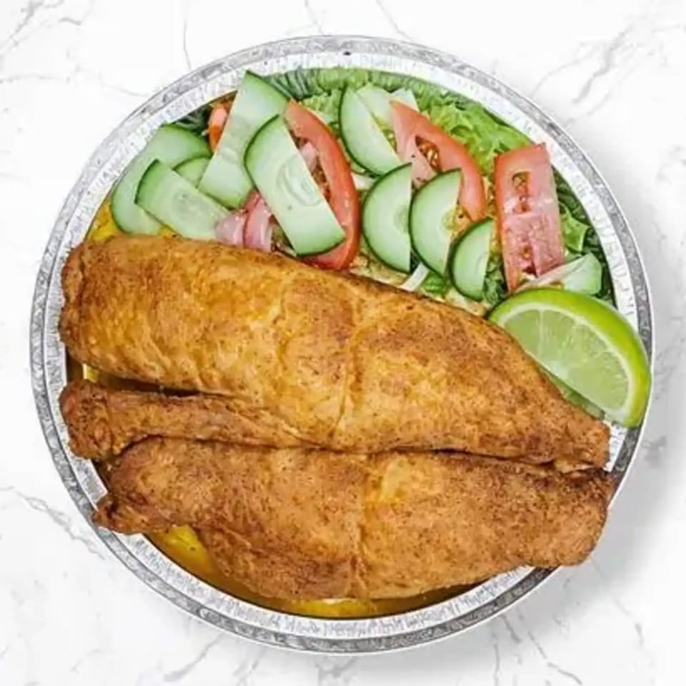 Fried fish fillets with a side salad of lettuce, tomatoes, cucumbers, and a lime wedge in a foil container.