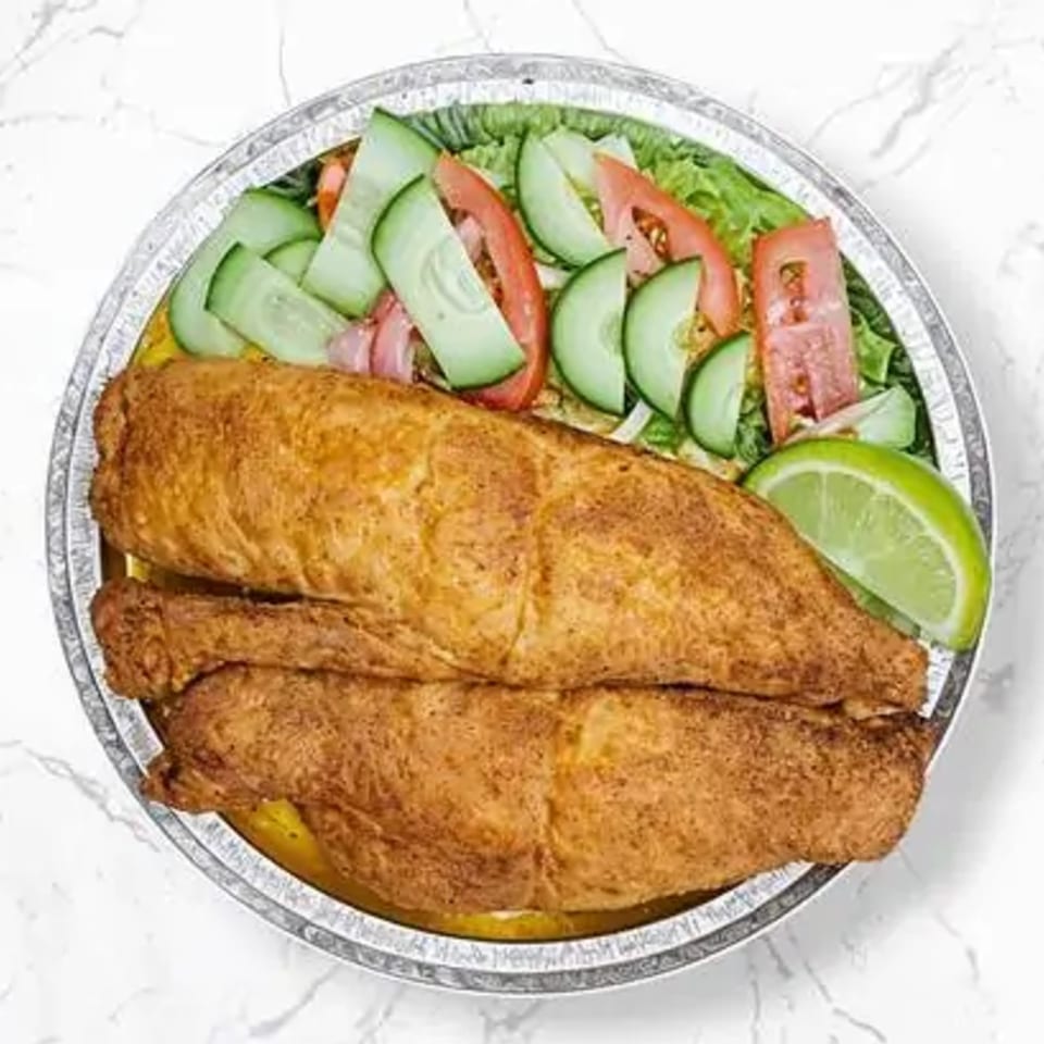 Halal fried fish fillets with a side salad of lettuce, cucumbers, tomatoes, and a lime wedge.